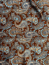 Load image into Gallery viewer, Deep brown, tan and blue paisley on a silky charmeuse satin fabric.
