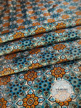 Load image into Gallery viewer, Super fun turquoise, blue, teal, gray and orange floral print on a silky charmeuse fabric.
