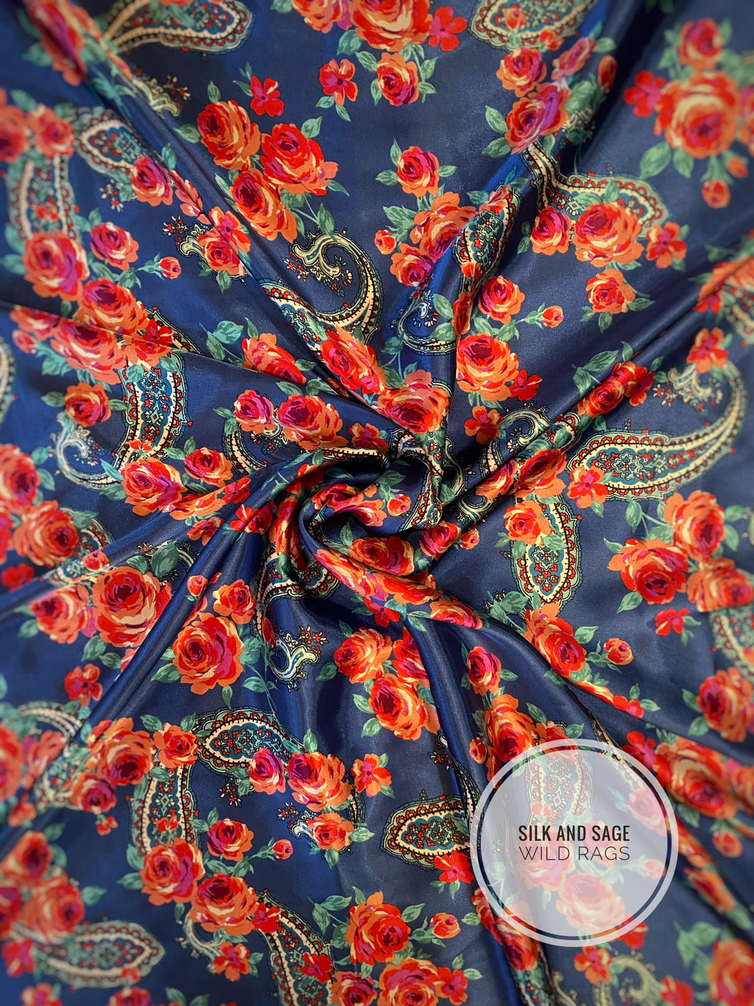 Bright blue background with stunning pink and red roses with green and turquoise flowers and paisley and a super silky charmeuse fabric.